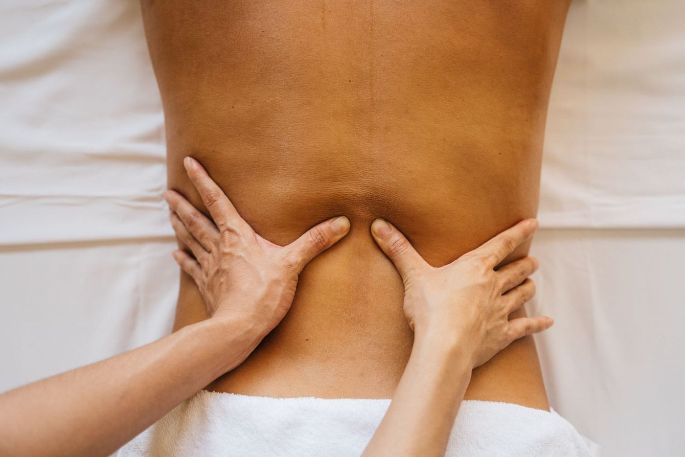 Manos de fisioterapeuta tratando la espalda de un paciente